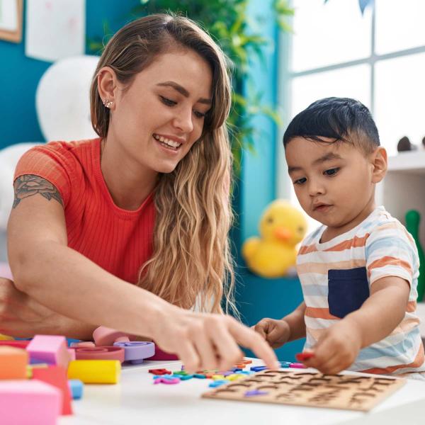 Childcare educator playing with a puzzle with child